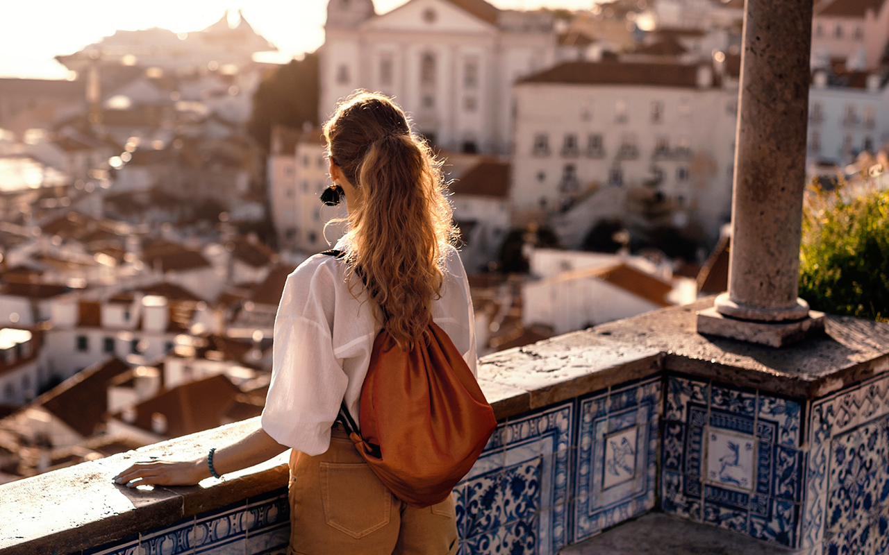 Female tourist looking at old town from balcony