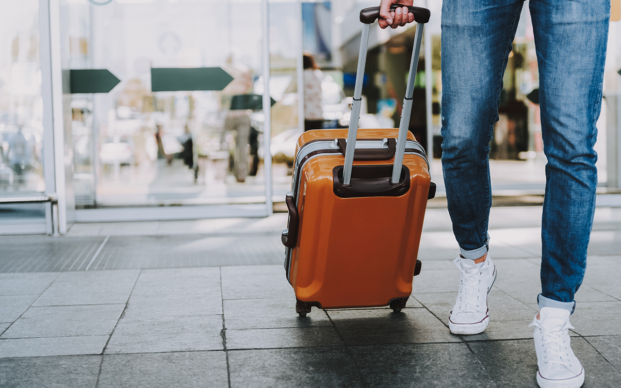 Man rolling a suitcase through the airport