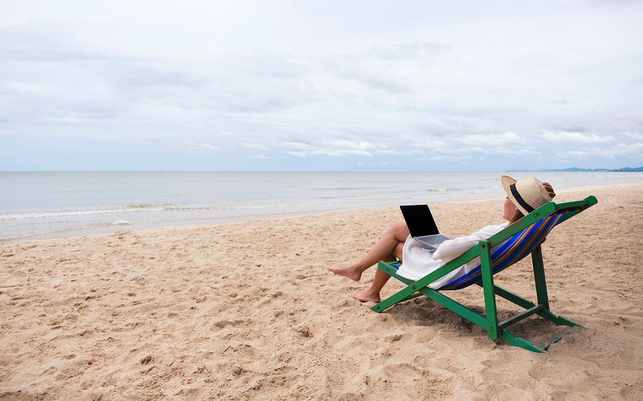 Woman on laptop at beach