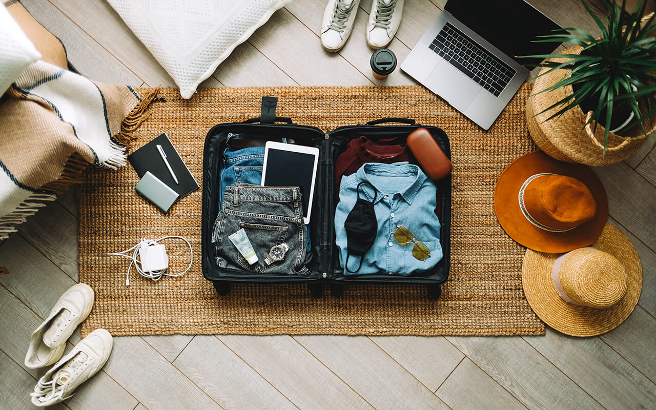 Packing suitcase for travel vacation in new normal, top view.