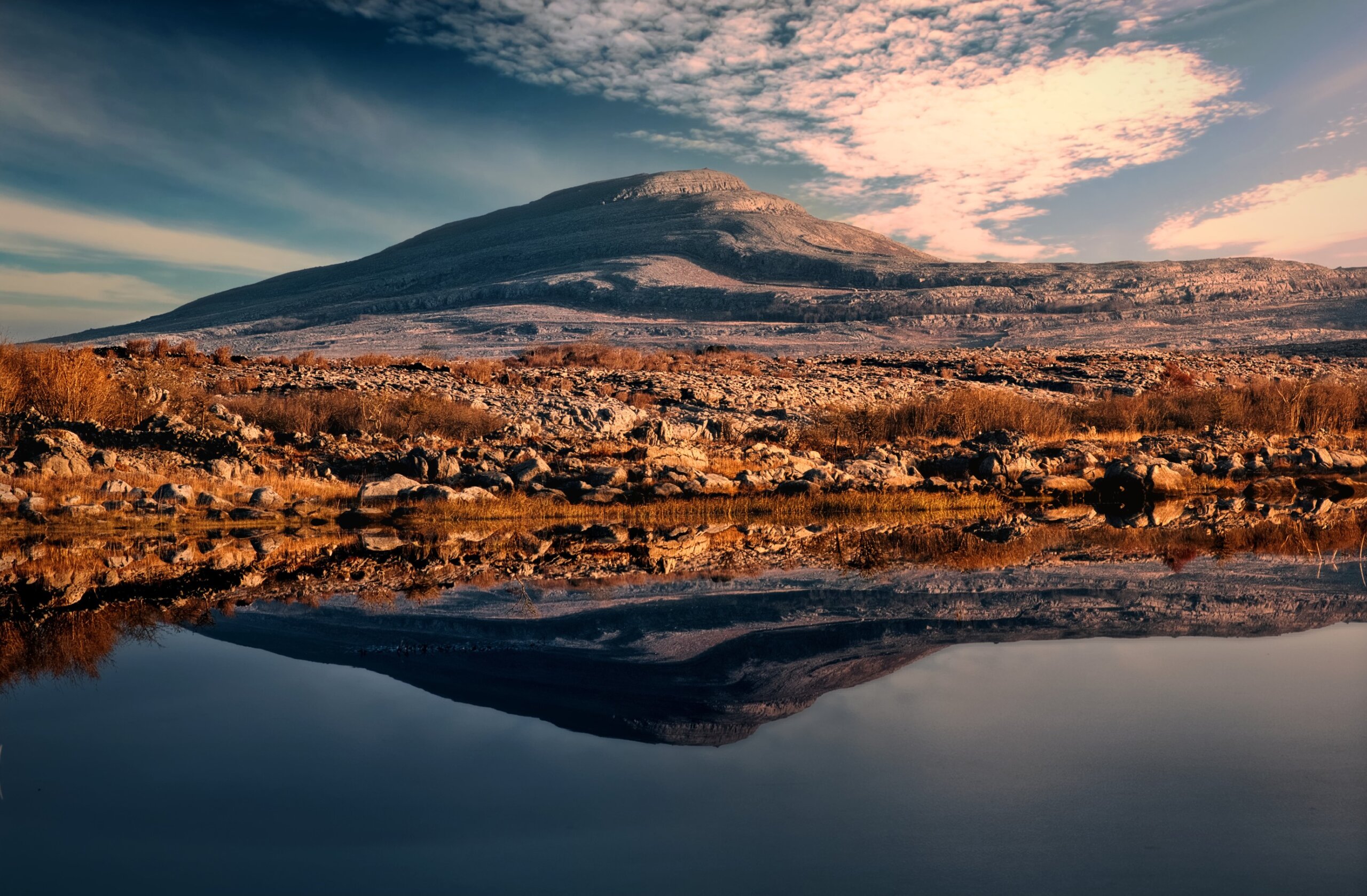 Beautiful morning landscape scenery of Mullaghmore mountain reflected in Lake at Burren National Park in county Clare, Ireland
