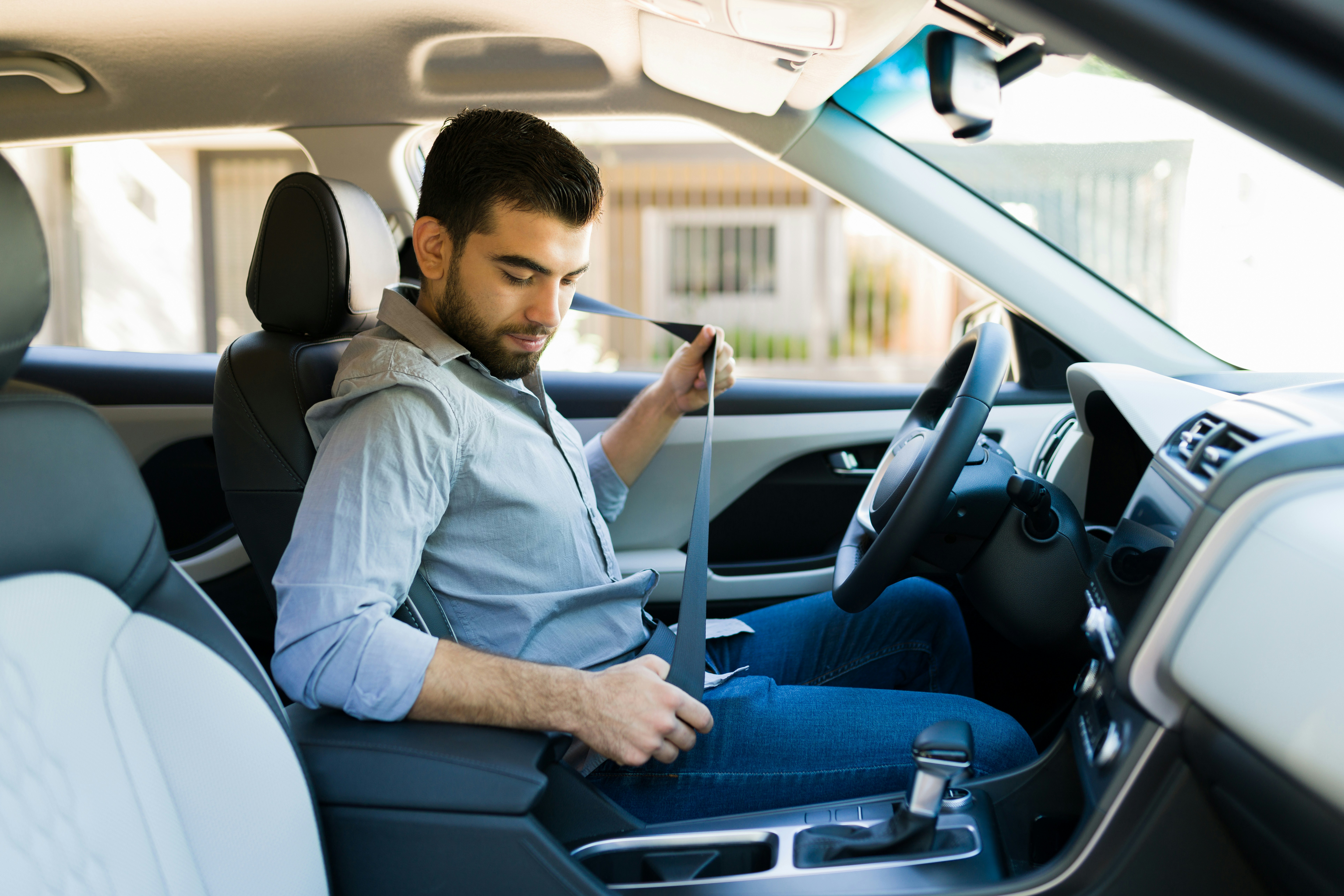 Man buckling seatbelt in car