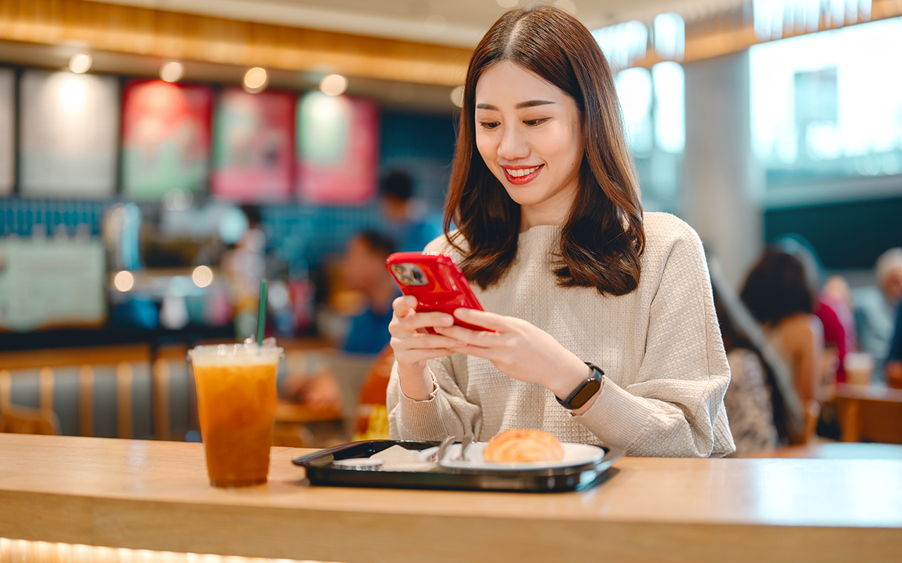 Woman with smart phone at a restaurant