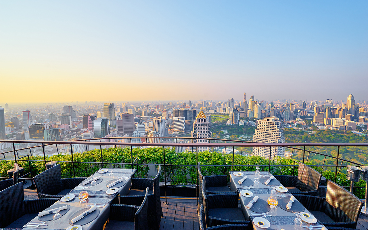 Table setting on roof top restaurant with megapolis view, Bangkok Thailand.