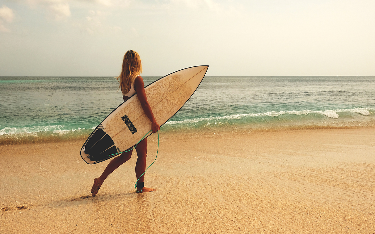 Woman on the beach with surf board