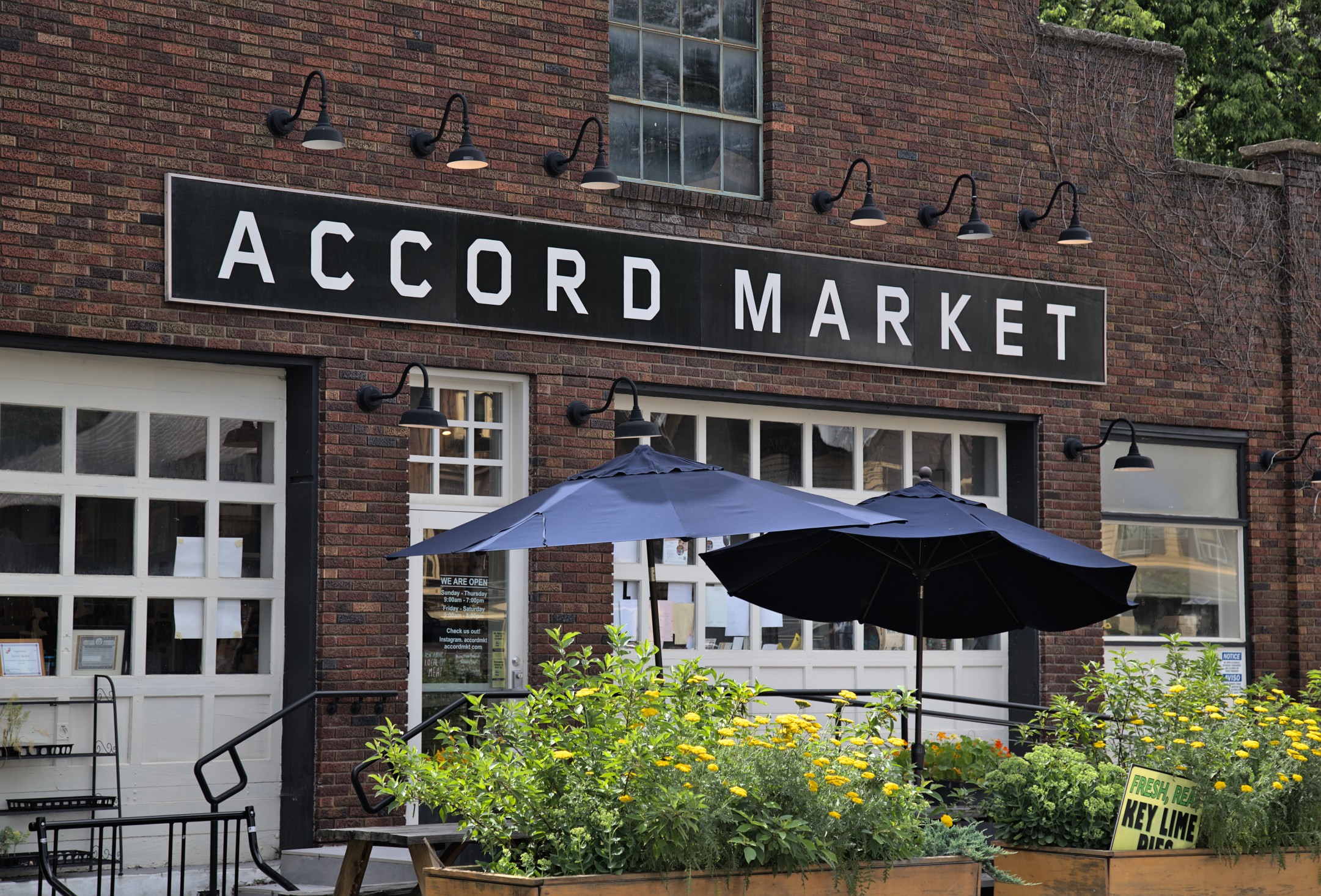 Accord Market sign with umbrellas and planter boxes in upstate New York, Hudson Valley.
