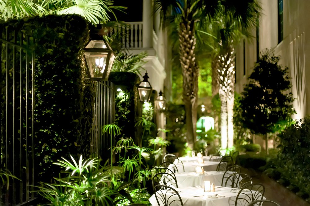 Candlelit courtyard restaurant surrounded by greenery, representing small-town foodie havens in the U.S.