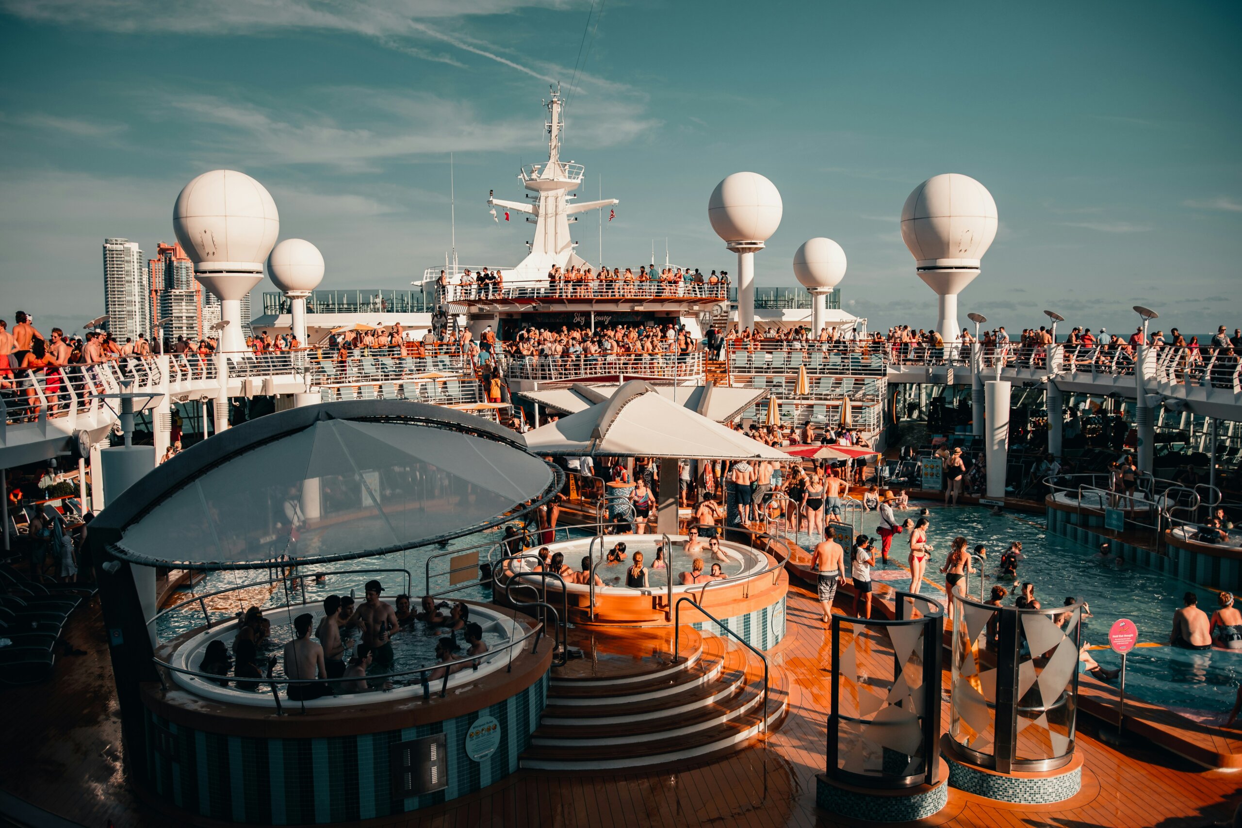 Crowded cruise ship pool deck with passengers, showing one of the reasons to cancel your cruise like long lines, noise, and limited space