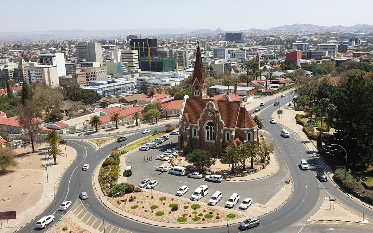 Aerial view of Christuskirche in Windhoek, Namibia surrounded by city streets and modern downtown skyline