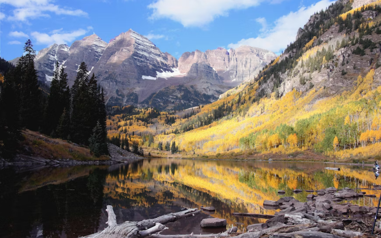 A river winds through the steep rocky mountain terrain of Maroon Bell's Park in Colorado.