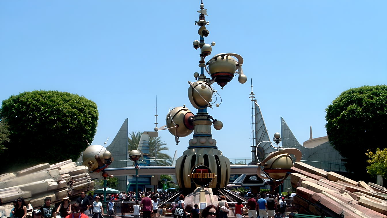Futuristic metallic sculpture at the entrance of Disney’s Tomorrowland Speedway, featuring sleek, curved lines and race-inspired design elements.