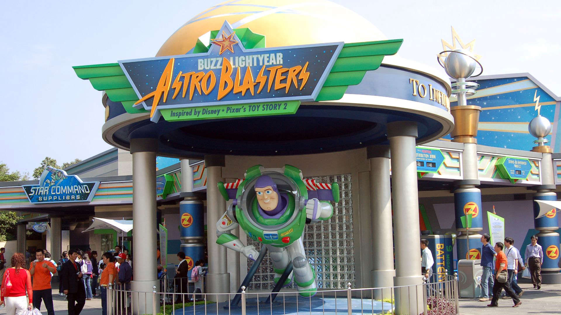 Disney’s Buzz Lightyear’s Space Ranger Spin, featuring bold signage with Buzz Lightyear artwork, vibrant galactic colors, and metallic space station design elements.