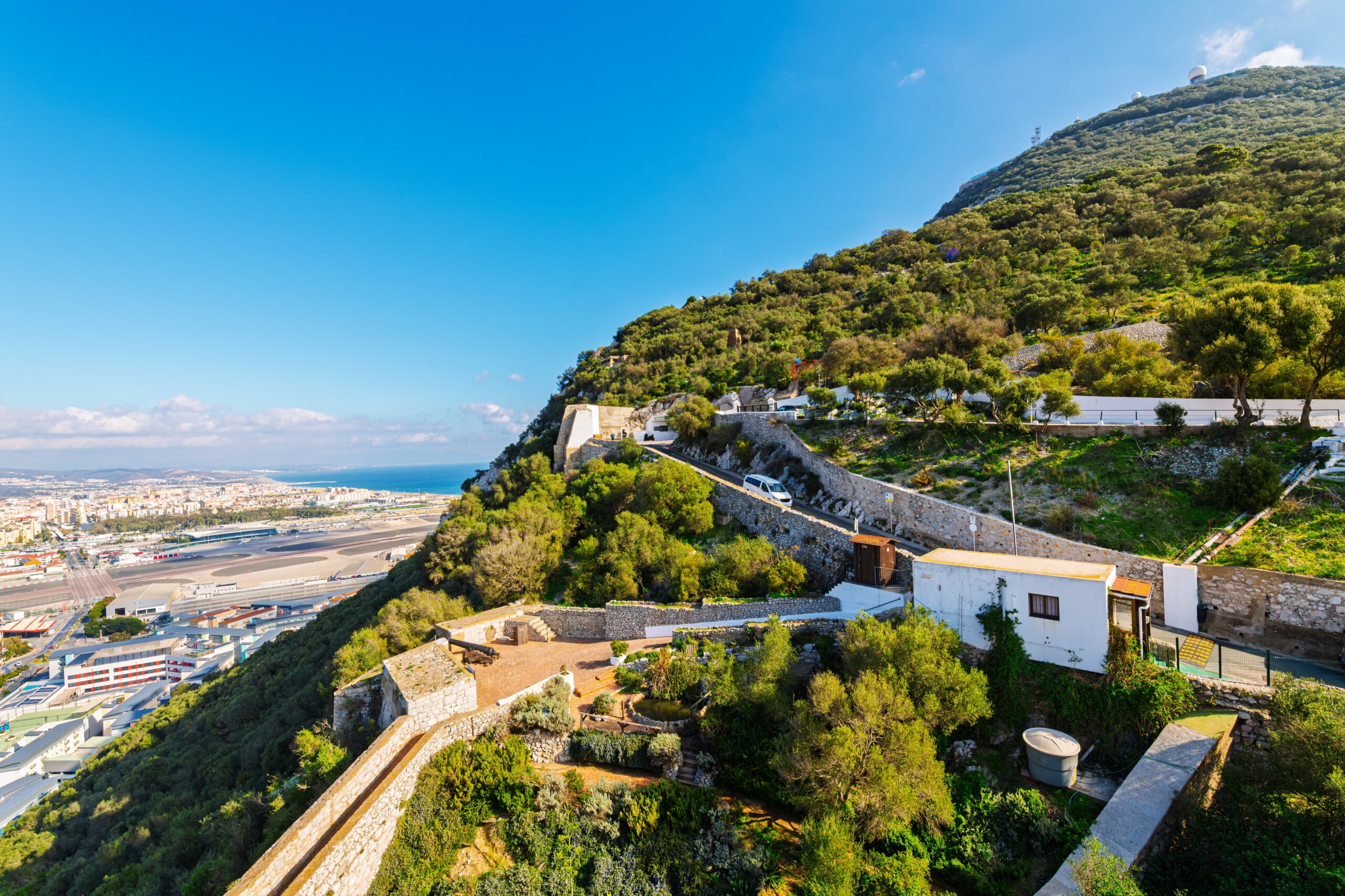 Moorish defensive walls and World War II tunnels on the Northwest side of the Rock of Gibraltar with the Mediterranean Sea and Spanish coastline in view, in Gibraltar, UK.