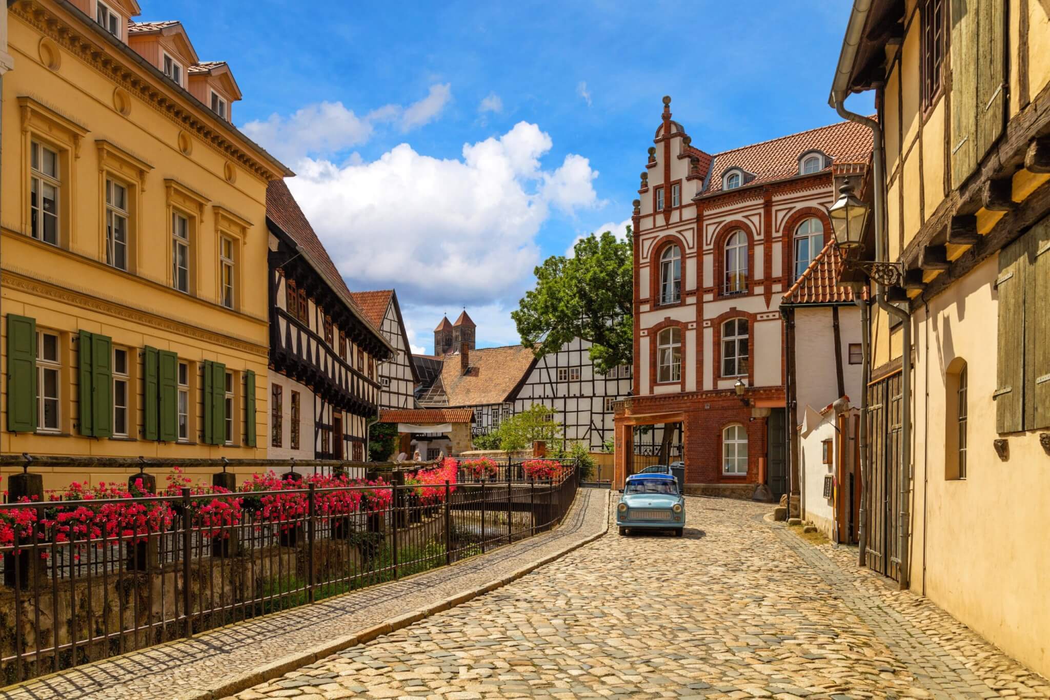 Colorful half-timbered townhouse with flower boxes and cobblestone street in the medieval Old Town of Quedlinburg, Germany—known for its fairytale charm and preserved timber architecture.