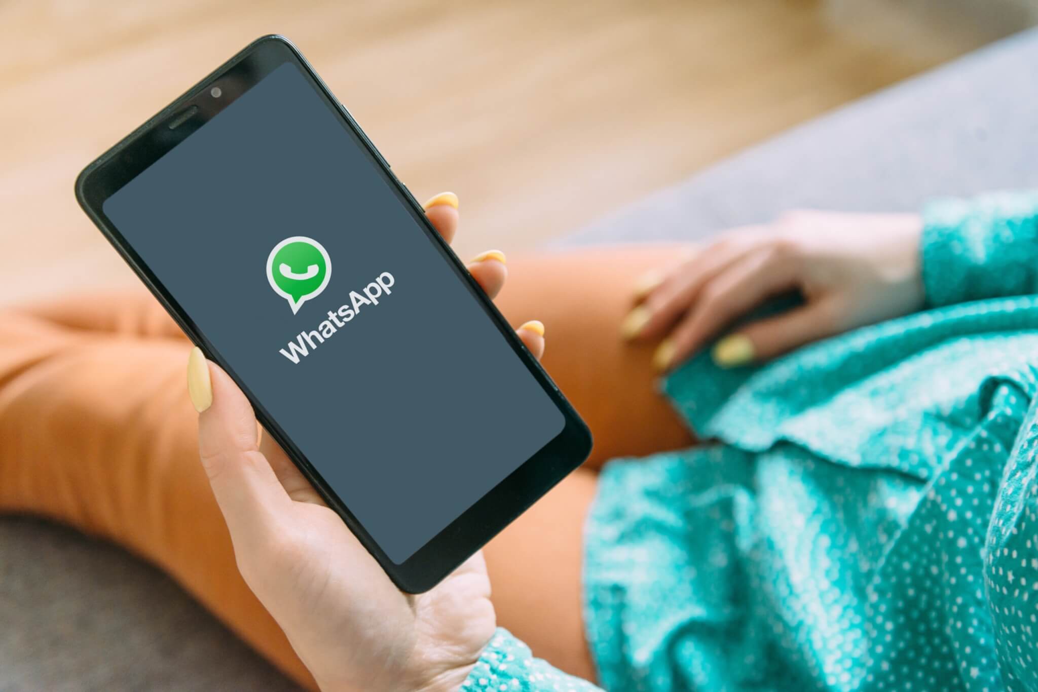 Young woman using WhatsApp on her smartphone.