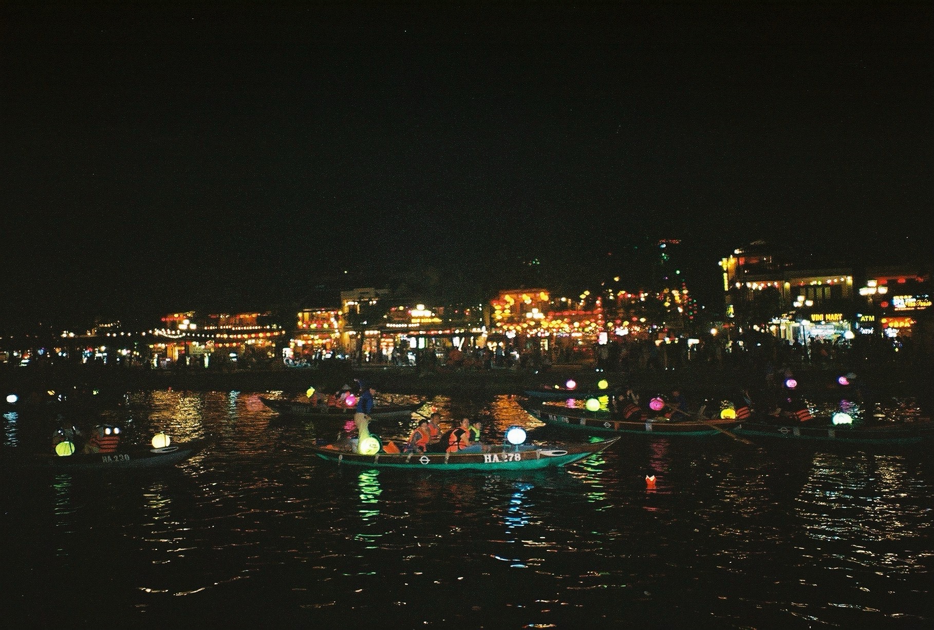 Lantern filled street and river at night in Hoi An