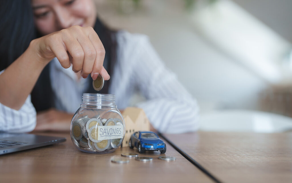 Woman putting coins in a jar marked
