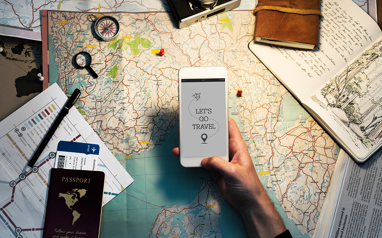 Closeup of hand with mobile phone over map background