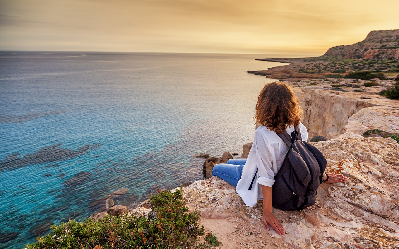 Woman sitting on a cliffside