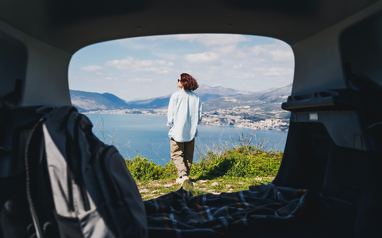Woman getting out of a van overlooking a cliff