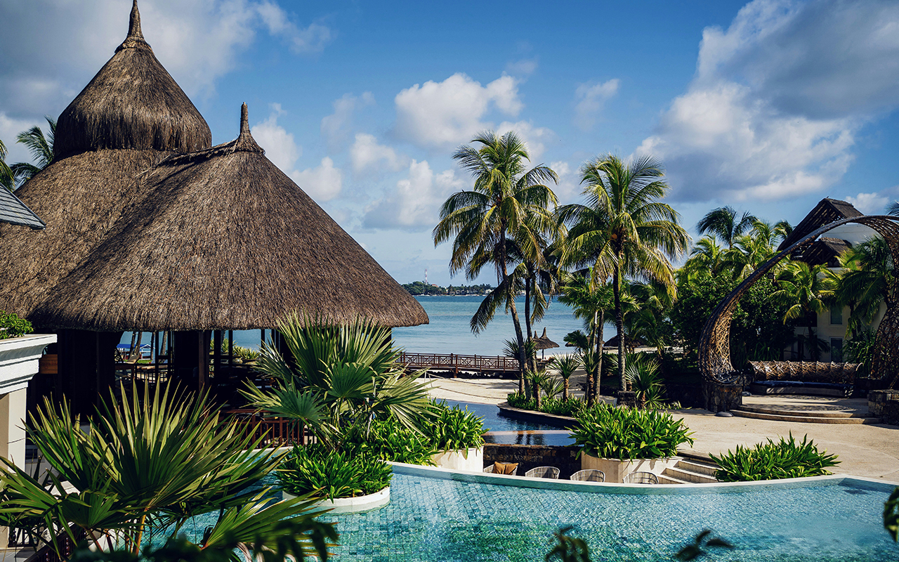 brown nipa hut near swimming pool during daytime
