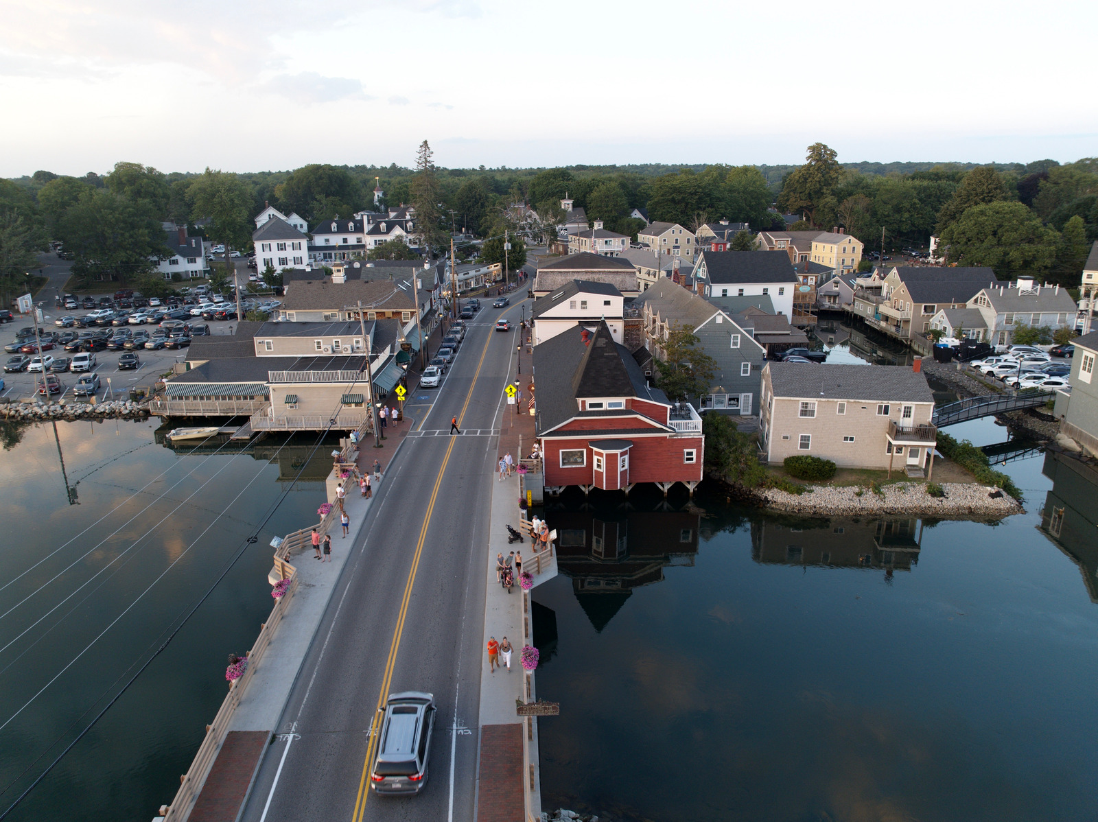 Aerial view of Kennebunkport, Maine, featuring a quaint coastal town, a small bridge over the river, and classic New England homes nestled along the shoreline.