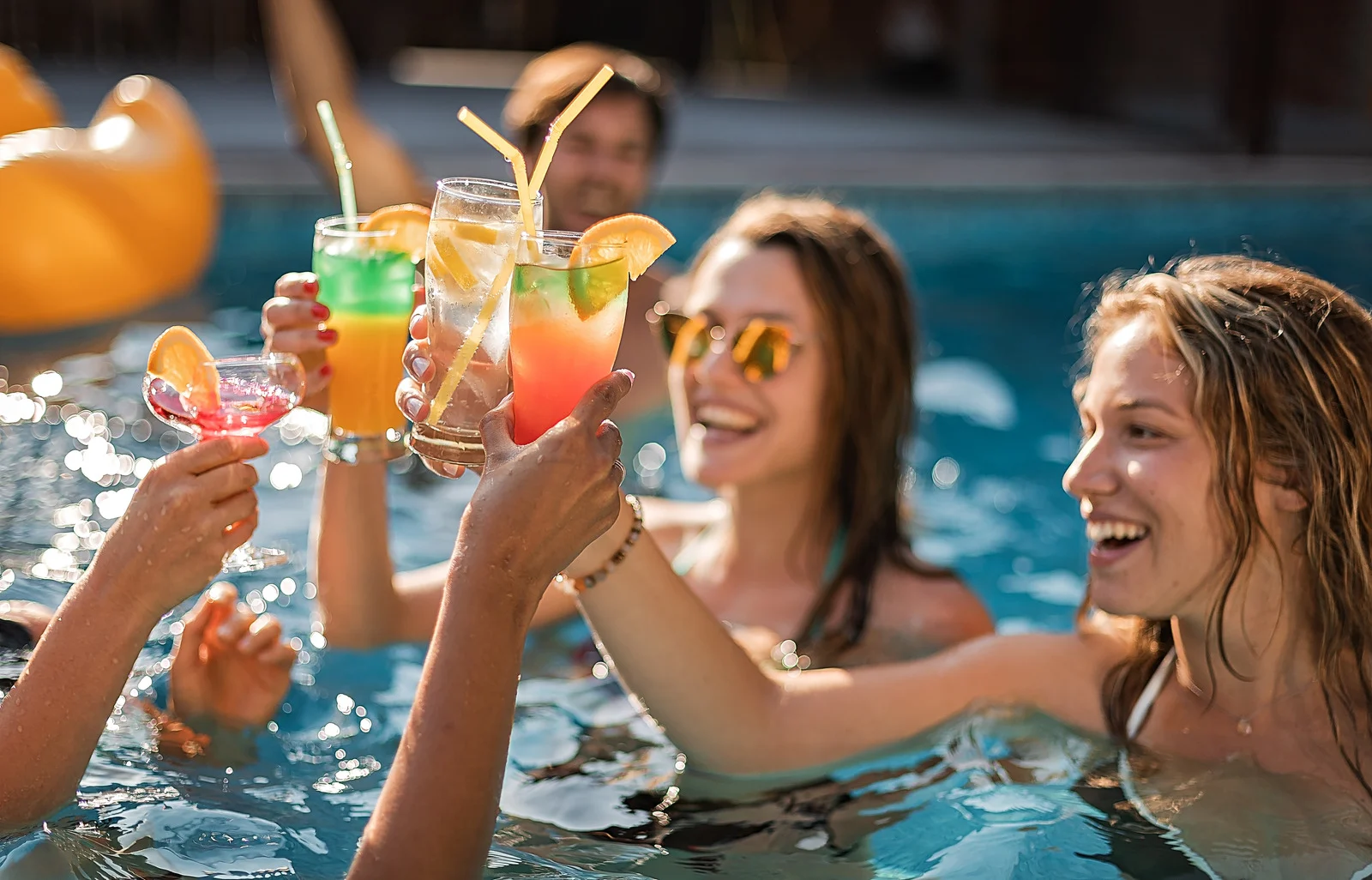 Women with drinks in a pool