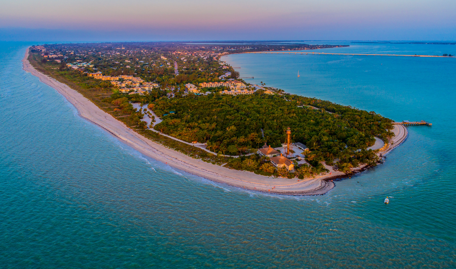 Aerial view of Sanibel Island, Florida, showcasing white sandy beaches, turquoise Gulf waters, and lush green vegetation along the coastline.