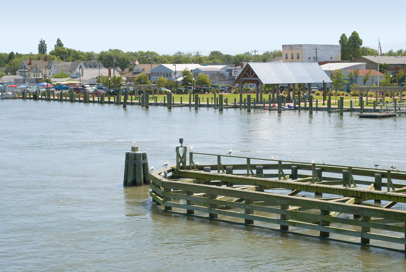 Peaceful waterfront scene in Chincoteague, Virginia, with wooden docks extending over calm water and a charming historic town in the background.