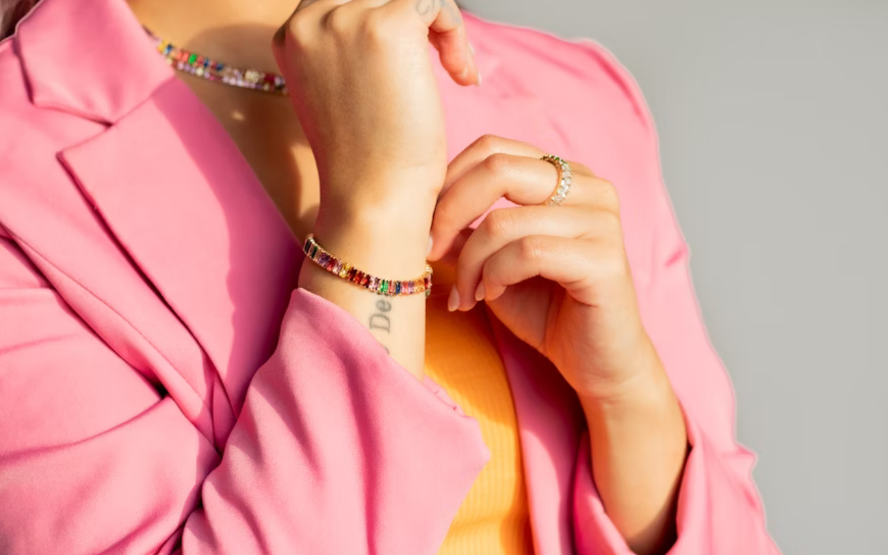 Woman in pink blazer showing off her fine jewelry 