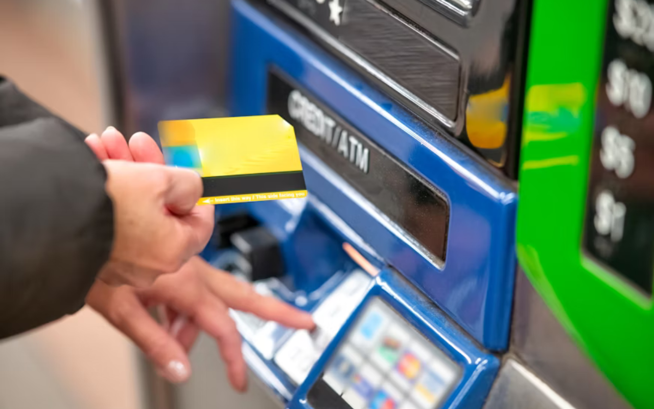 Man putting his debit card into an atm