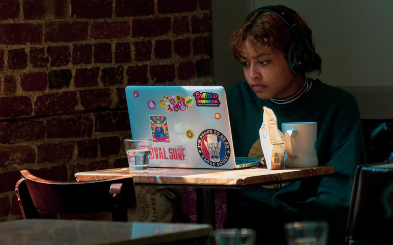 Young girl working on her laptop at a cafe