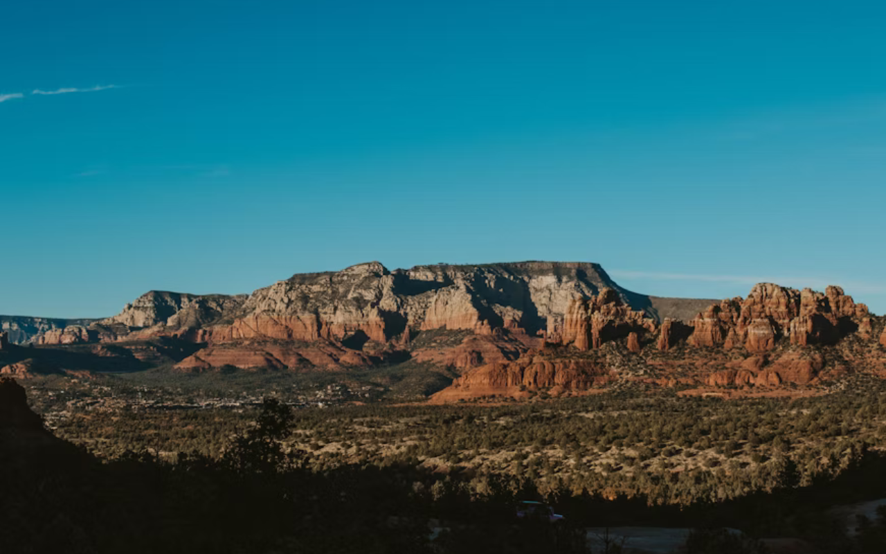 Dramatic red rock formations of Sedona with clear skies, offering a serene and restorative desert escape