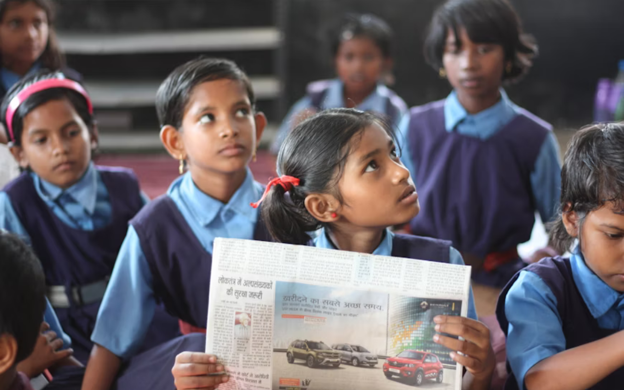 Volunteer teaching English to schoolchildren in a classroom in India.