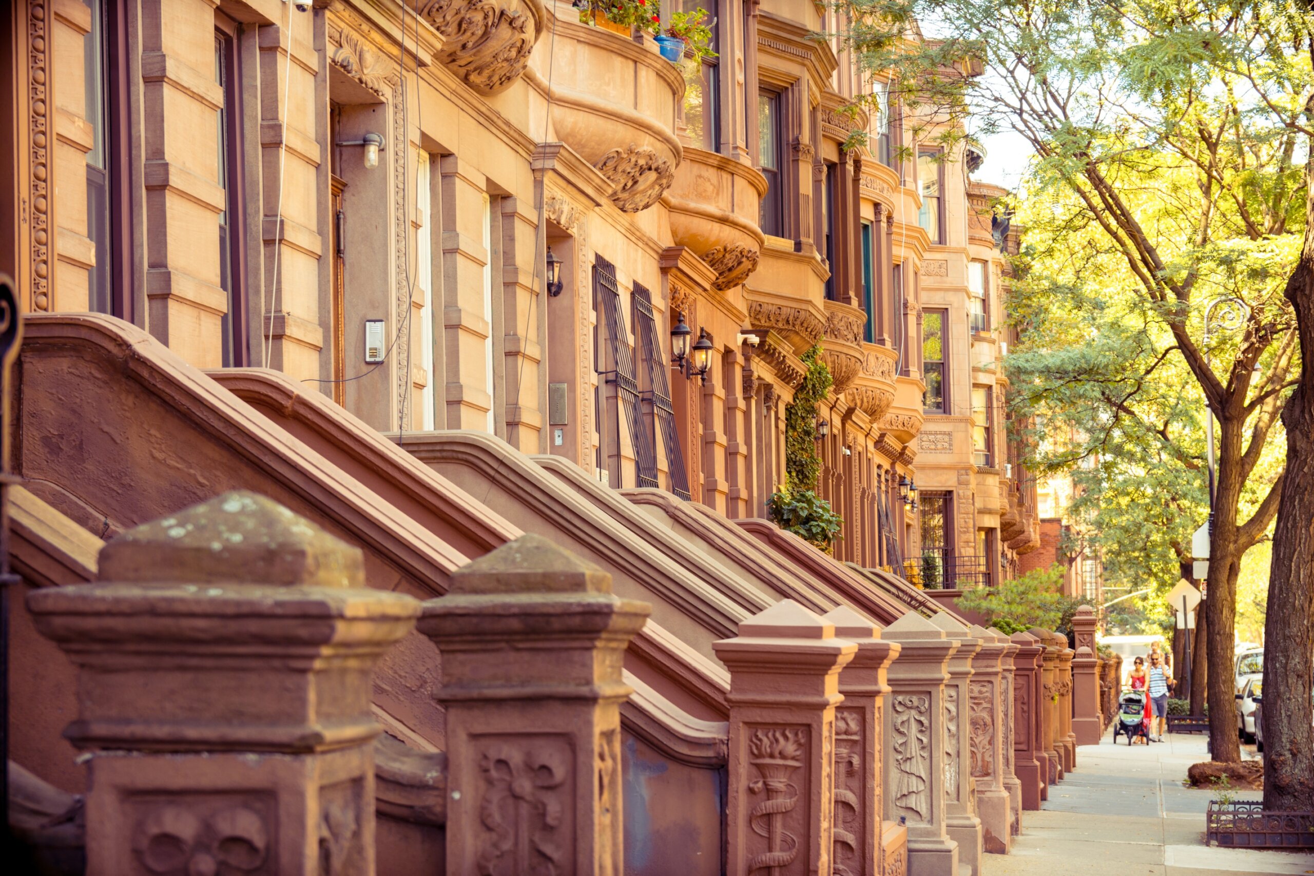 Harlem brownstone row houses with vibrant street life, reflecting New York City’s rich African American heritage