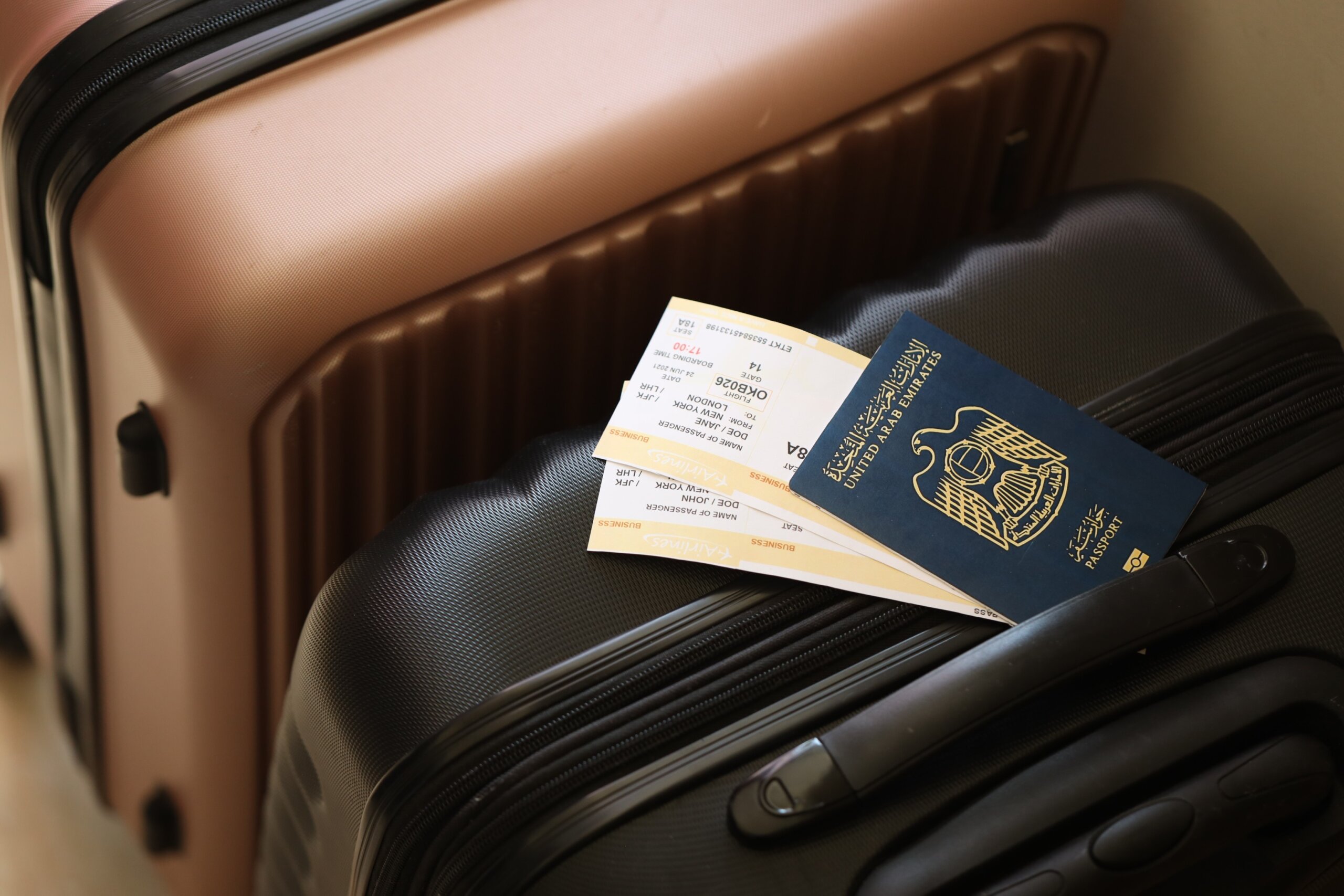 United Arab Emirates UAE passport with tickets lies on touristic suitcase close up in airport hall