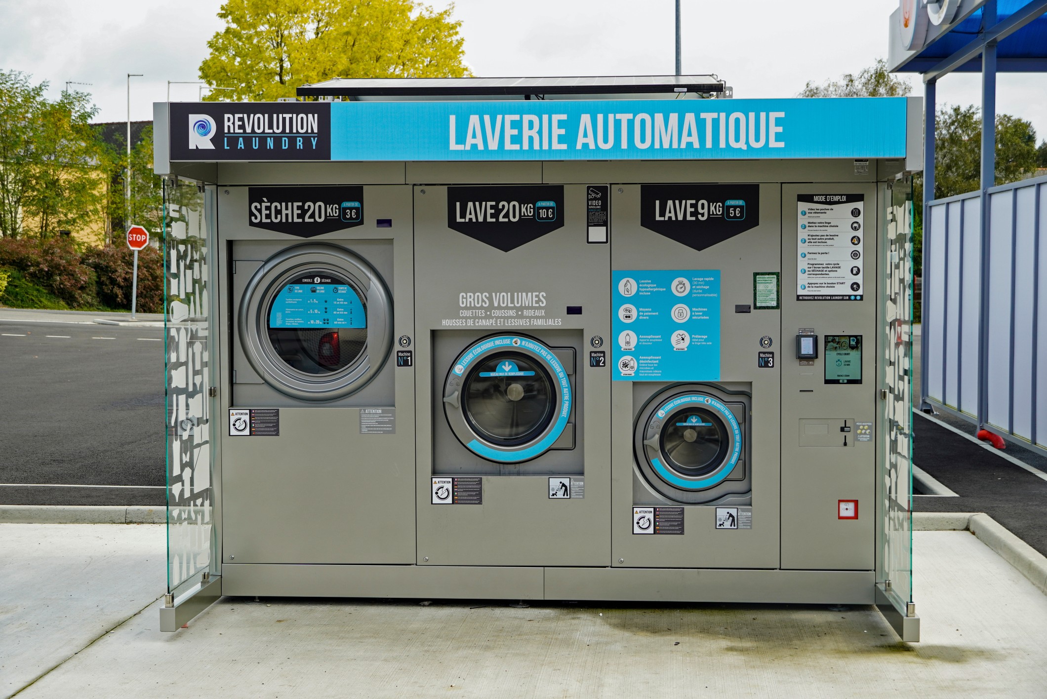 A growing trend in France, a covered outdoor clothes wash and dry facility in a rural supermarket parking lot in Many French homes do not have dryers.