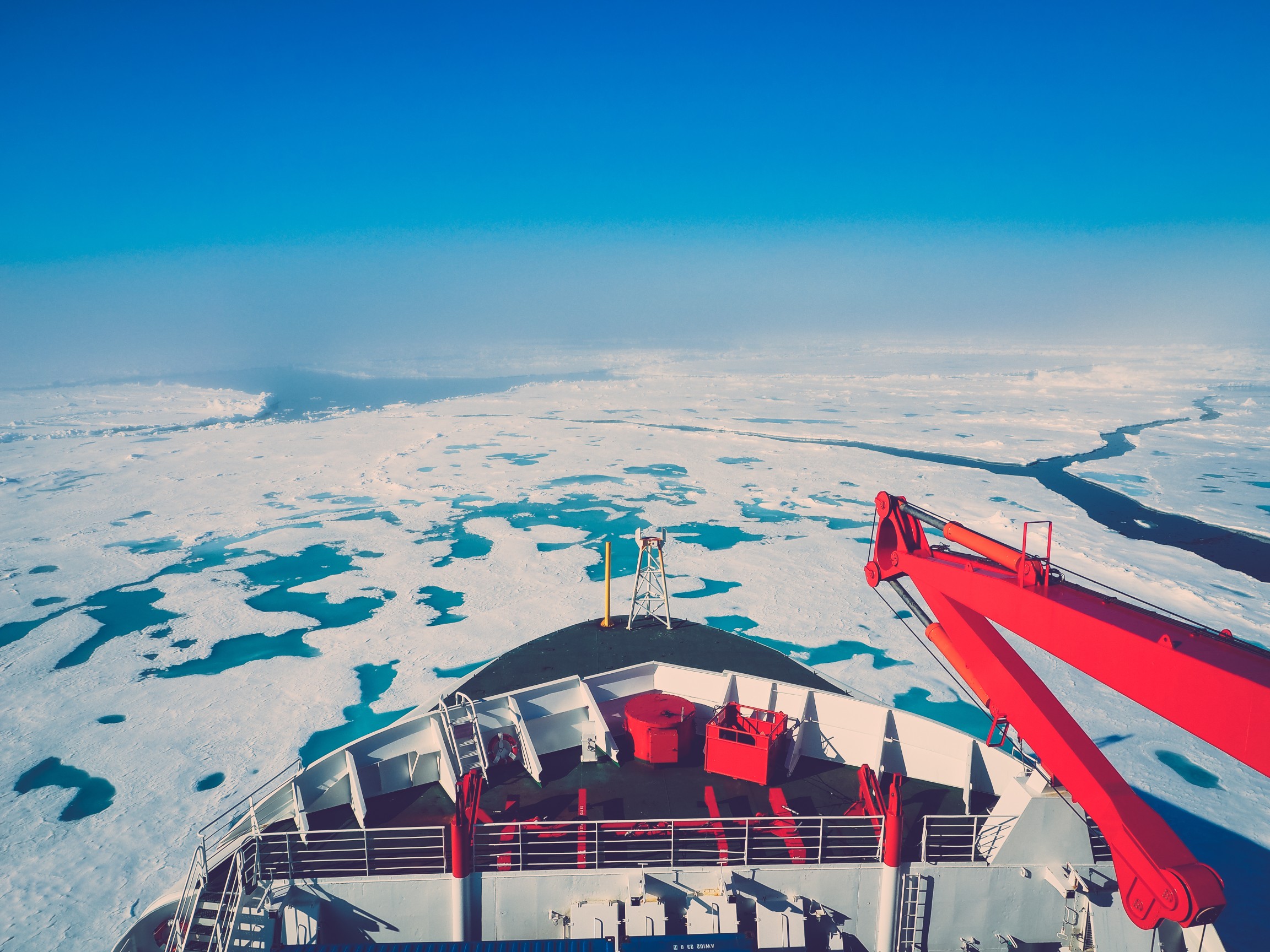 Icebreaker ship navigating through Arctic sea ice during polar expedition
