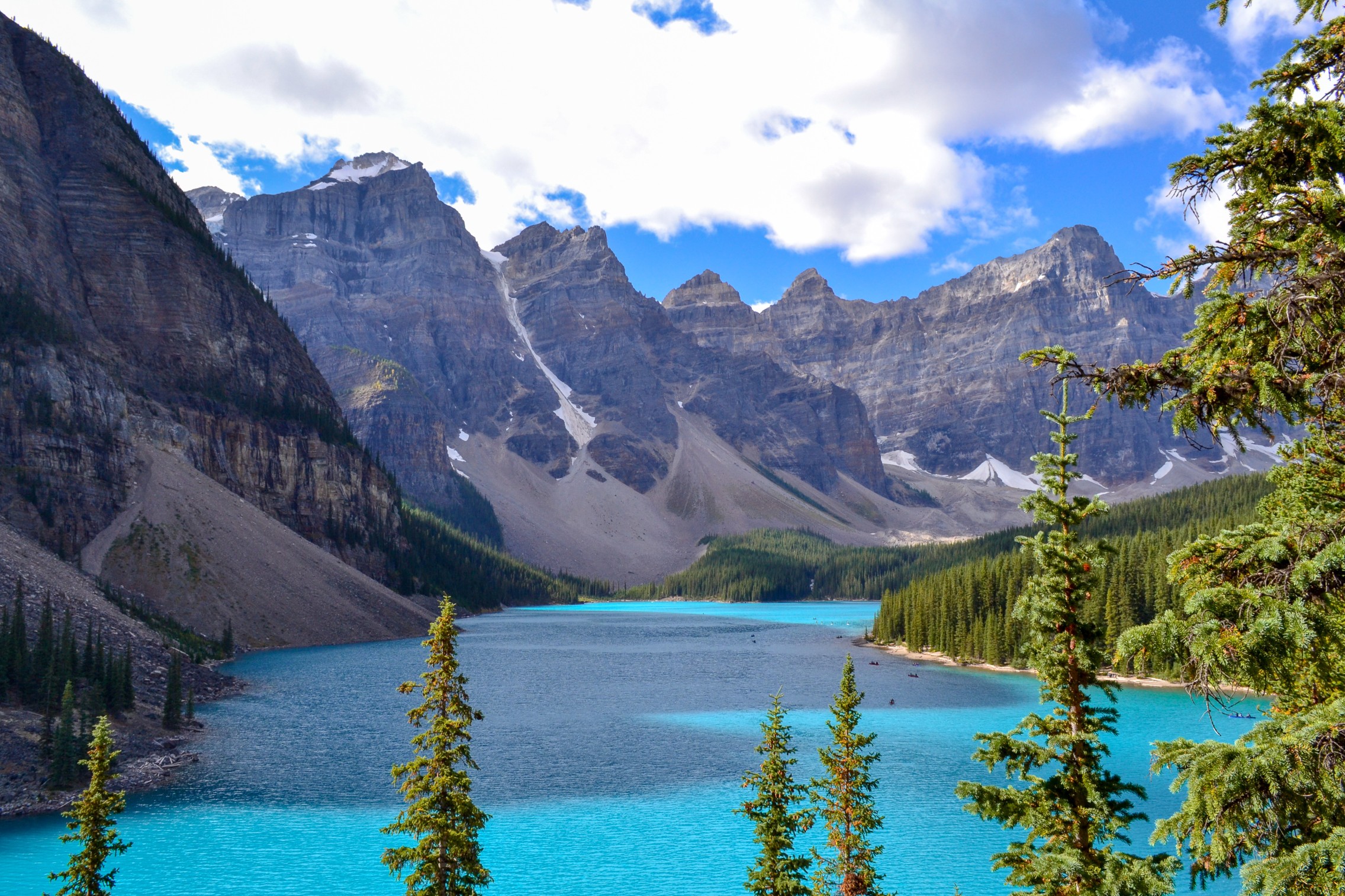 Iconic Canadian landscape, trip of a lifetime, Moraine Lake with it's glacier fed light blue turquoise waters and majestic peaks on a sunny day in the end of august, wilderness forest landscape.