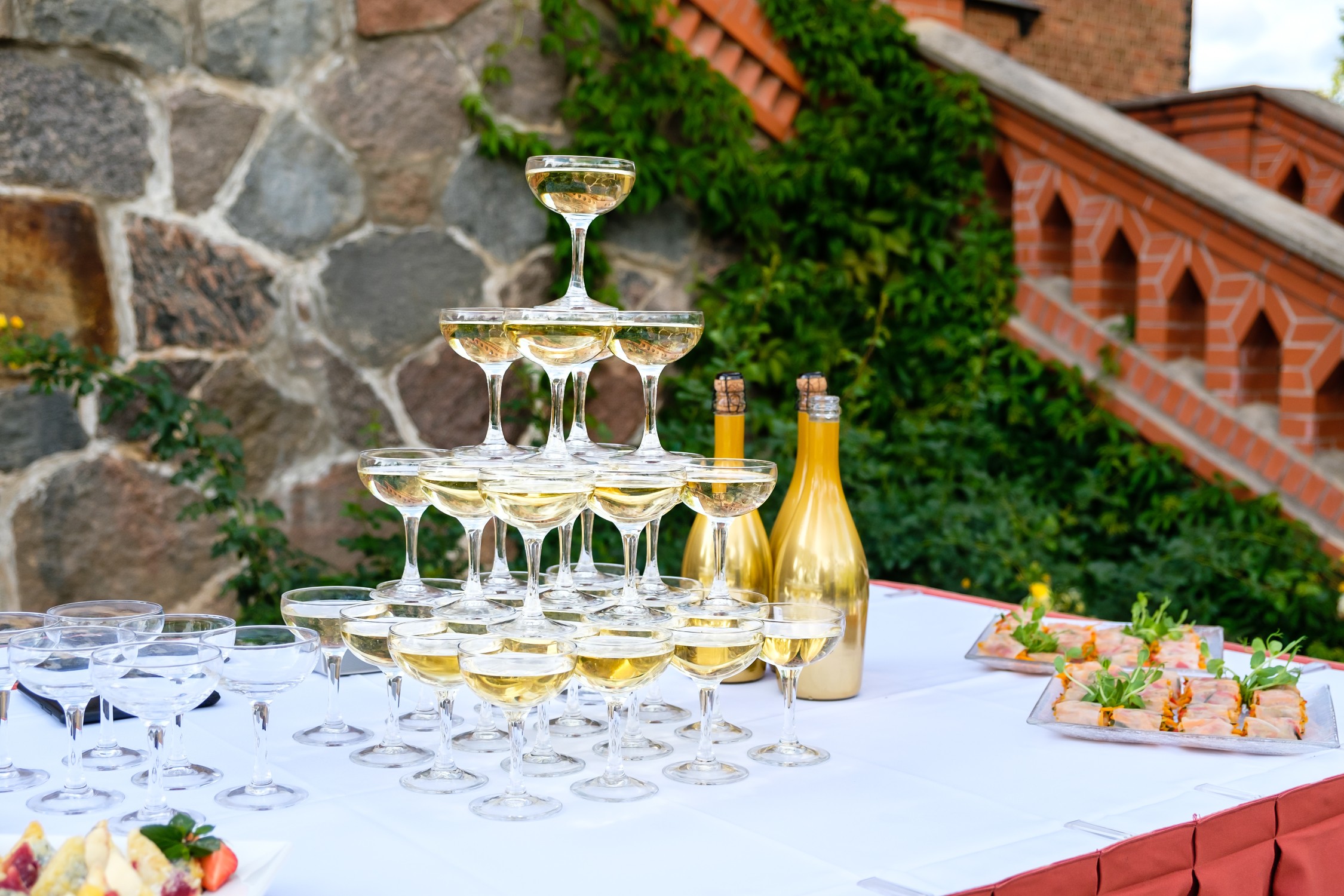 Tower of stacked champagne glasses filled for a wedding reception celebration.