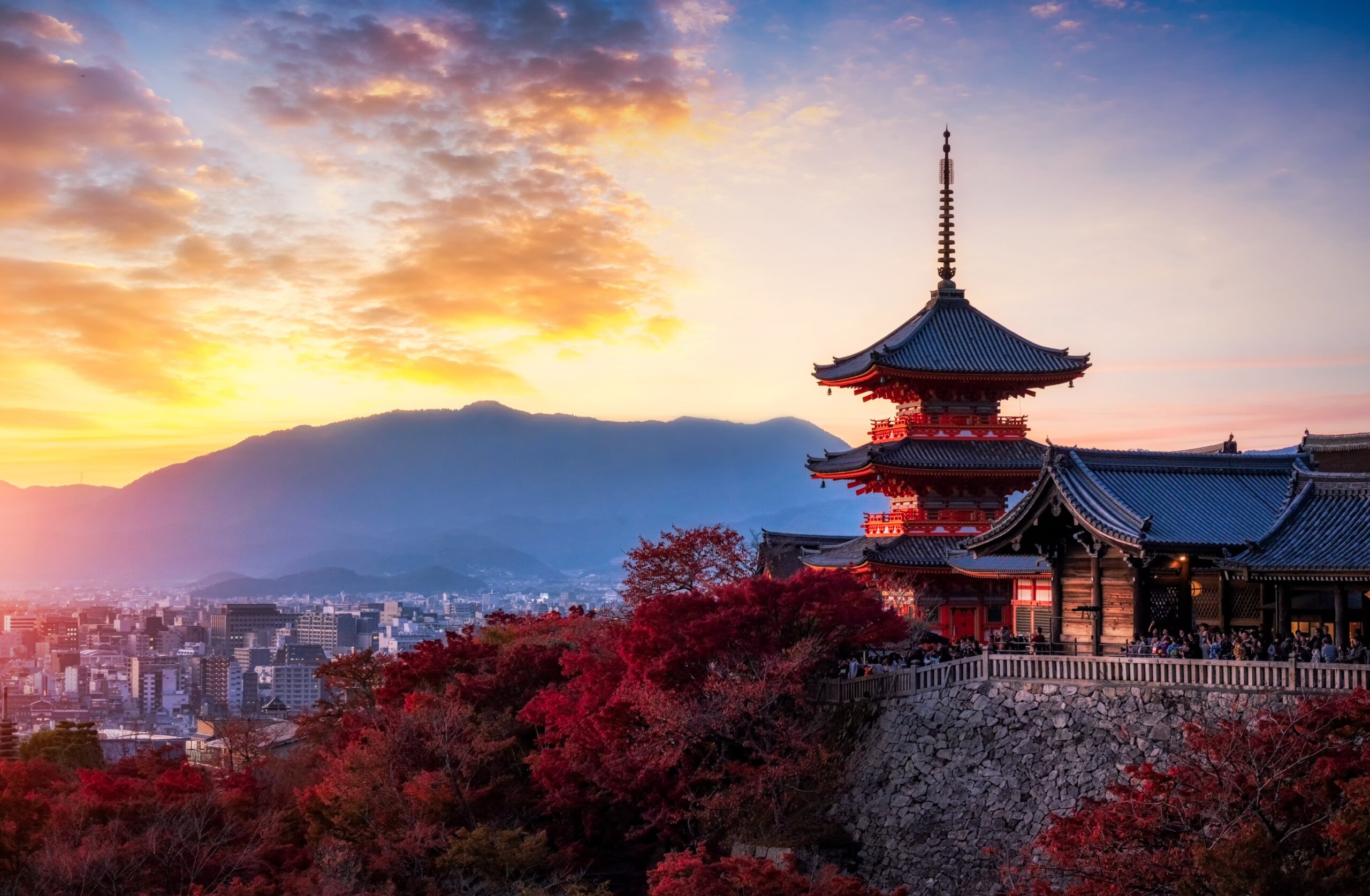 Sunset at Kiyomizu-dera Pagoda Temple with vibrant red maple leaves in autumn, a famous cultural landmark in Kyoto, Japan.