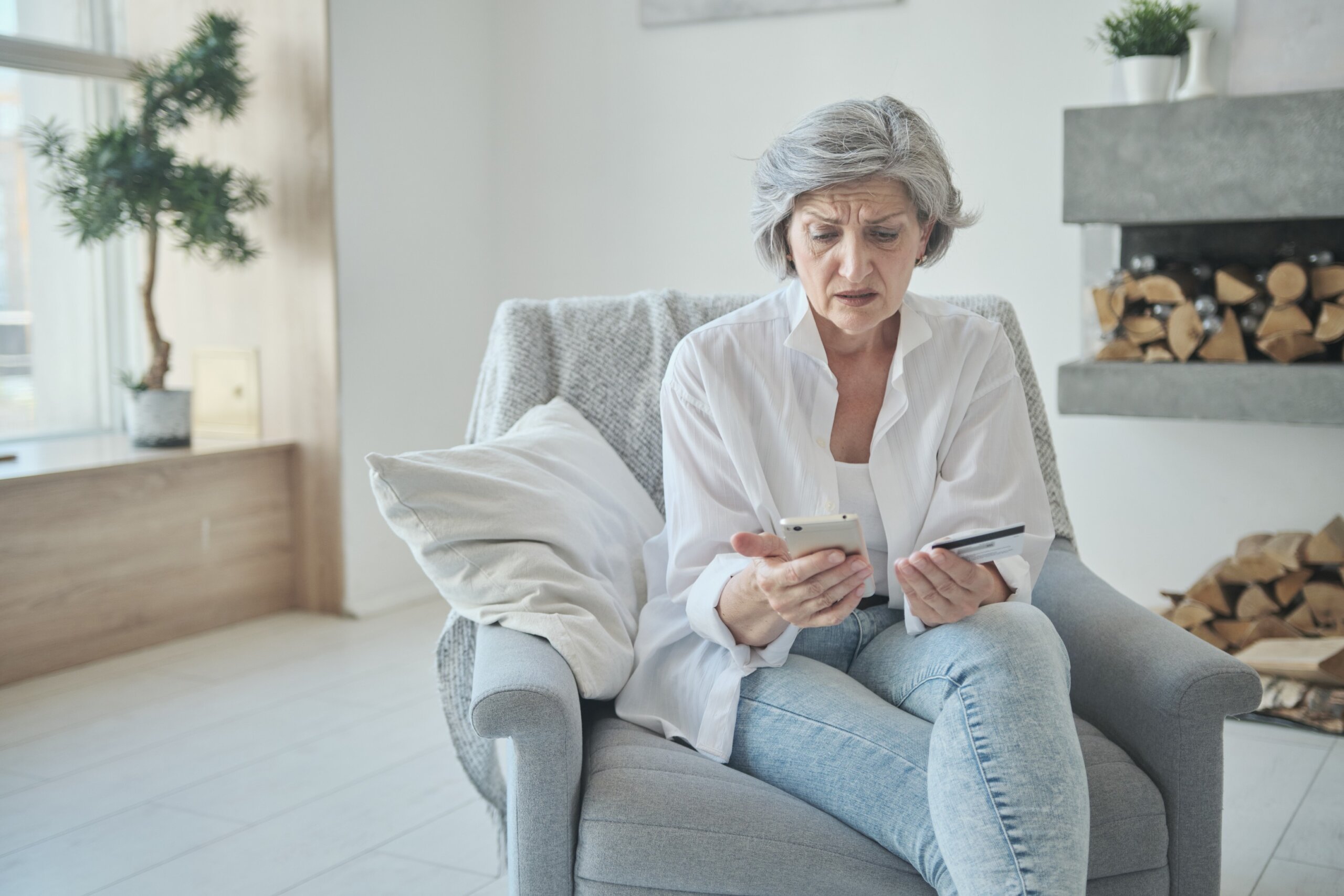 Caucasian senior woman using credit card and mobile phone for online shopping. Mature old retired female making purchase in internet stores. Instant ebanking. Elderly people's usage of technology