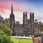 Panoramic sunset view of Edinburgh skyline featuring University of Edinburgh historic buildings and Old College dome.