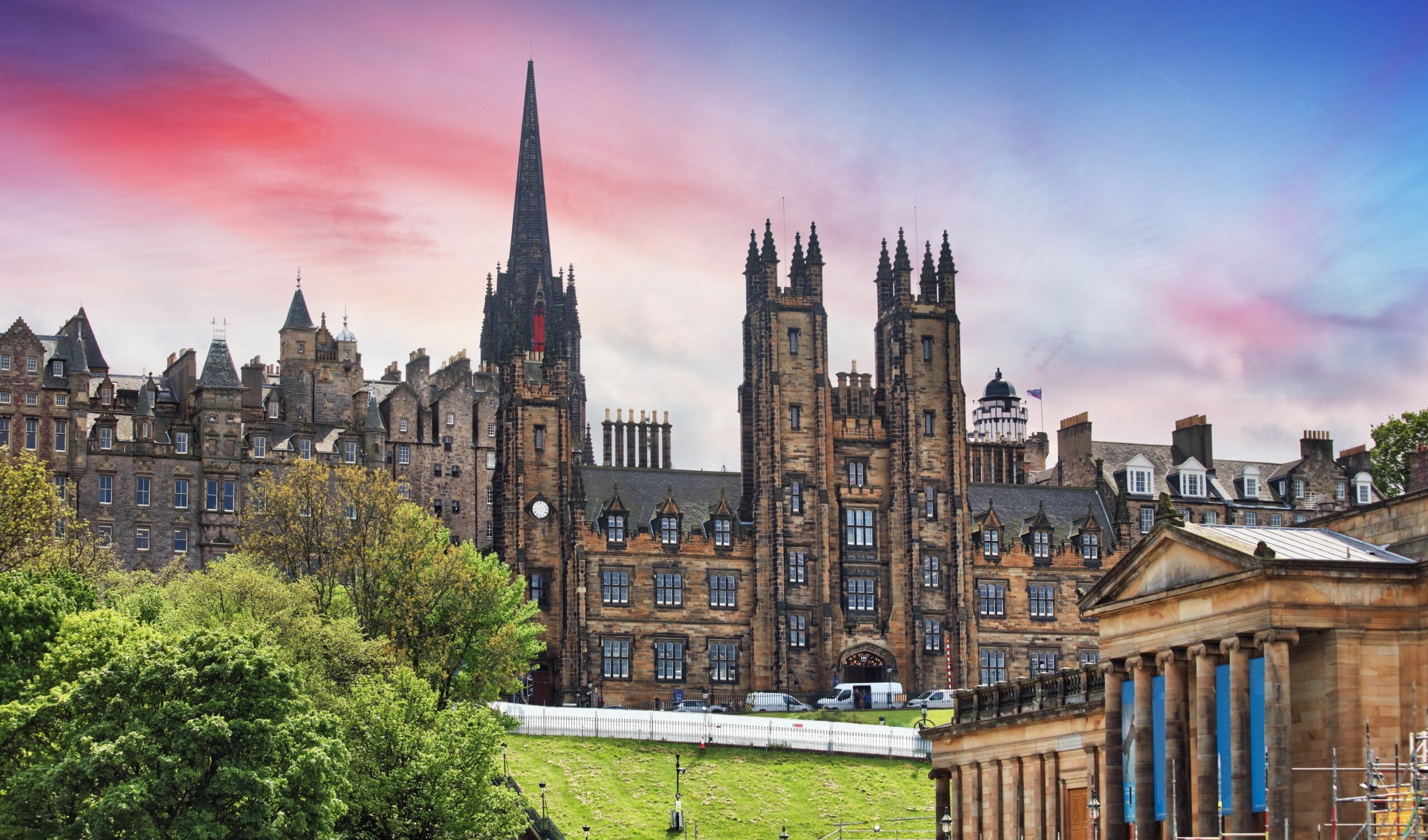 Panoramic sunset view of Edinburgh skyline featuring University of Edinburgh historic buildings and Old College dome.