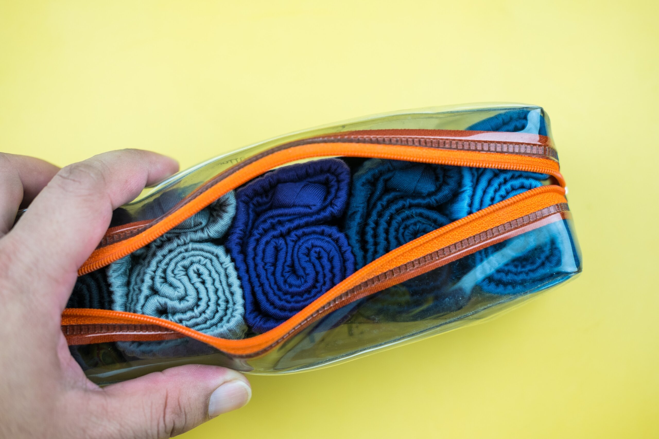 Man keep new cotton simple rolled men underwear in bag, prepared for travel.