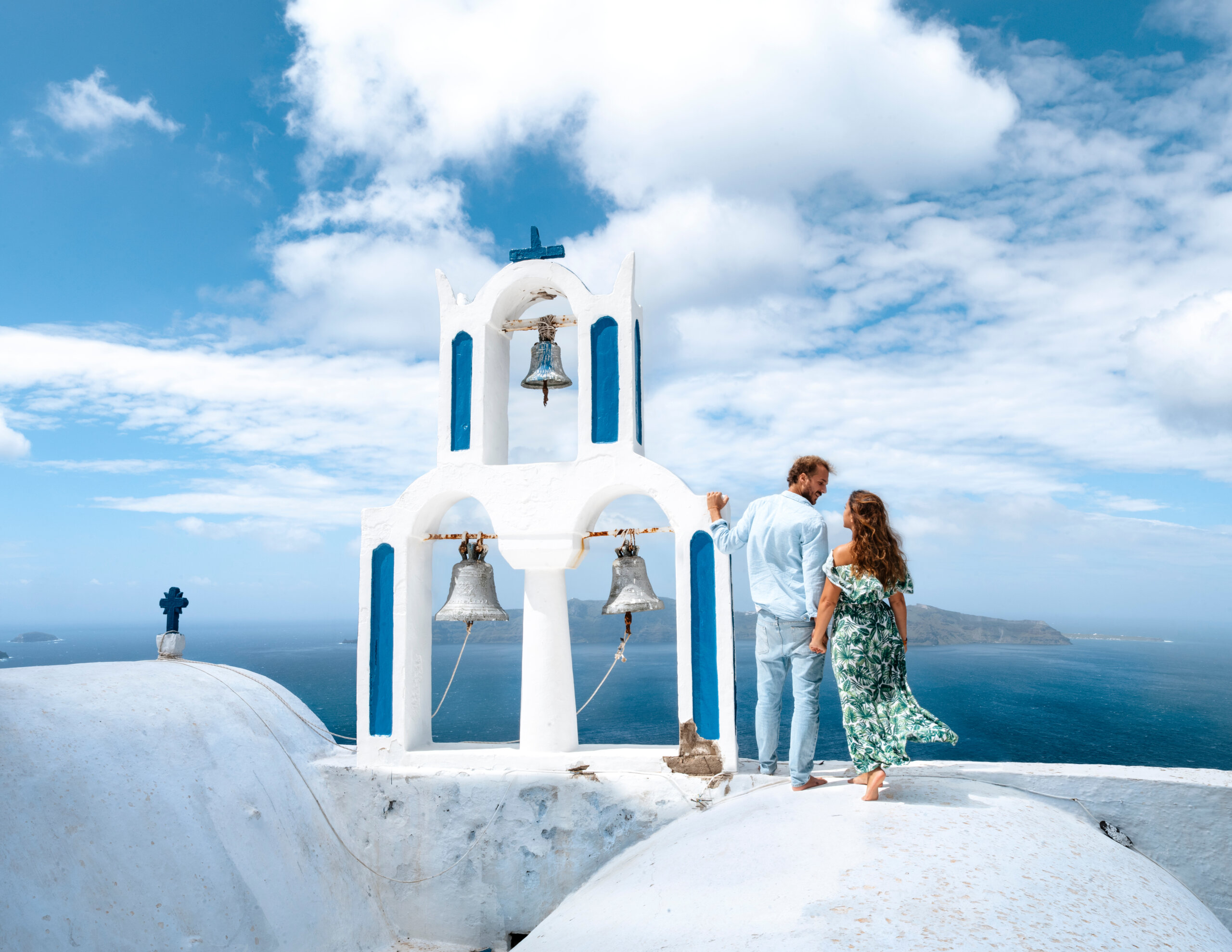 Young honeymoon couple in Oia Santorini Greece enjoying cliffside views – romantic Greek island honeymoon destination 2025