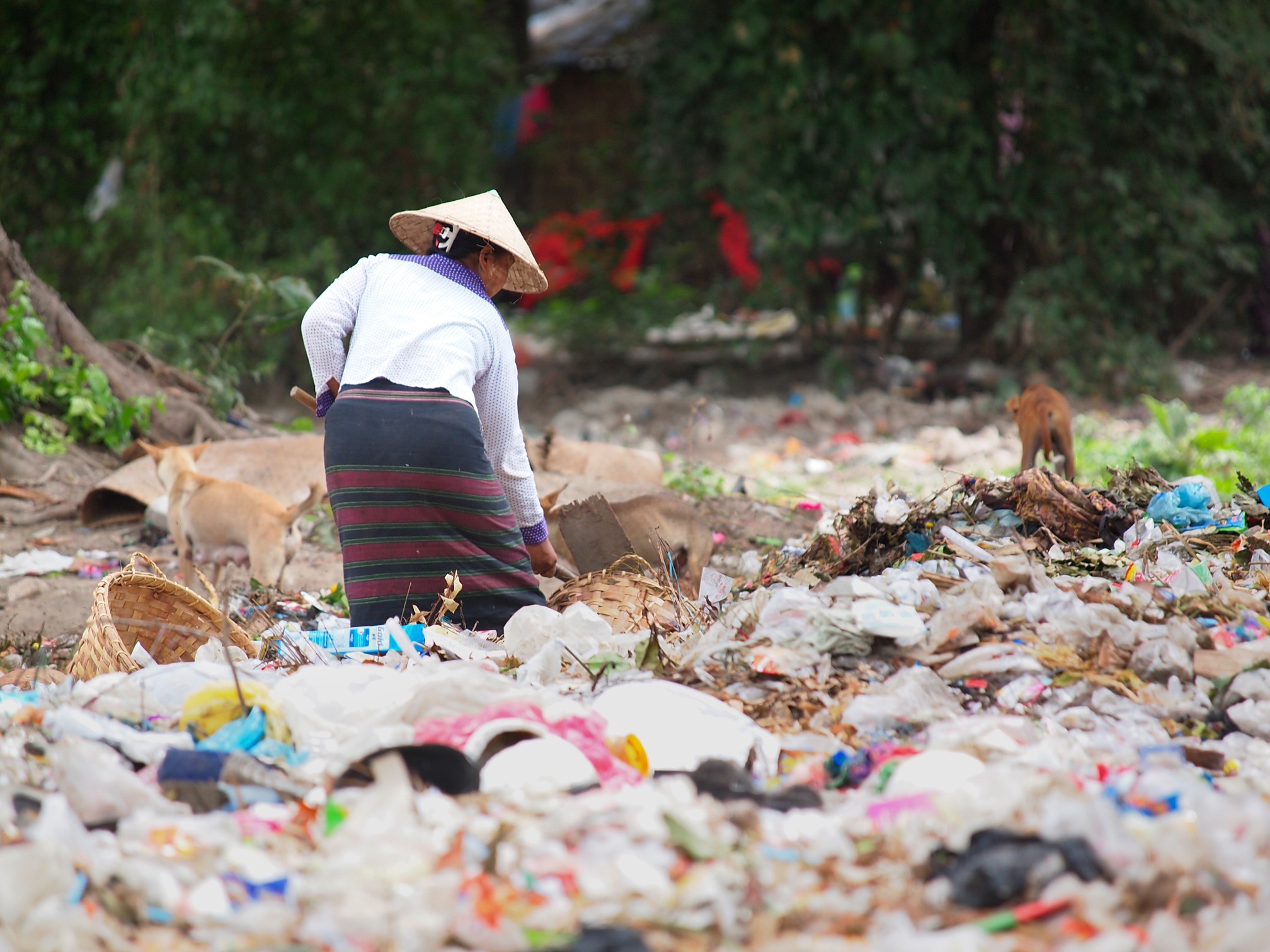 Burmese Volunteer cleaning the plastic mountain of garbage in Myanmar