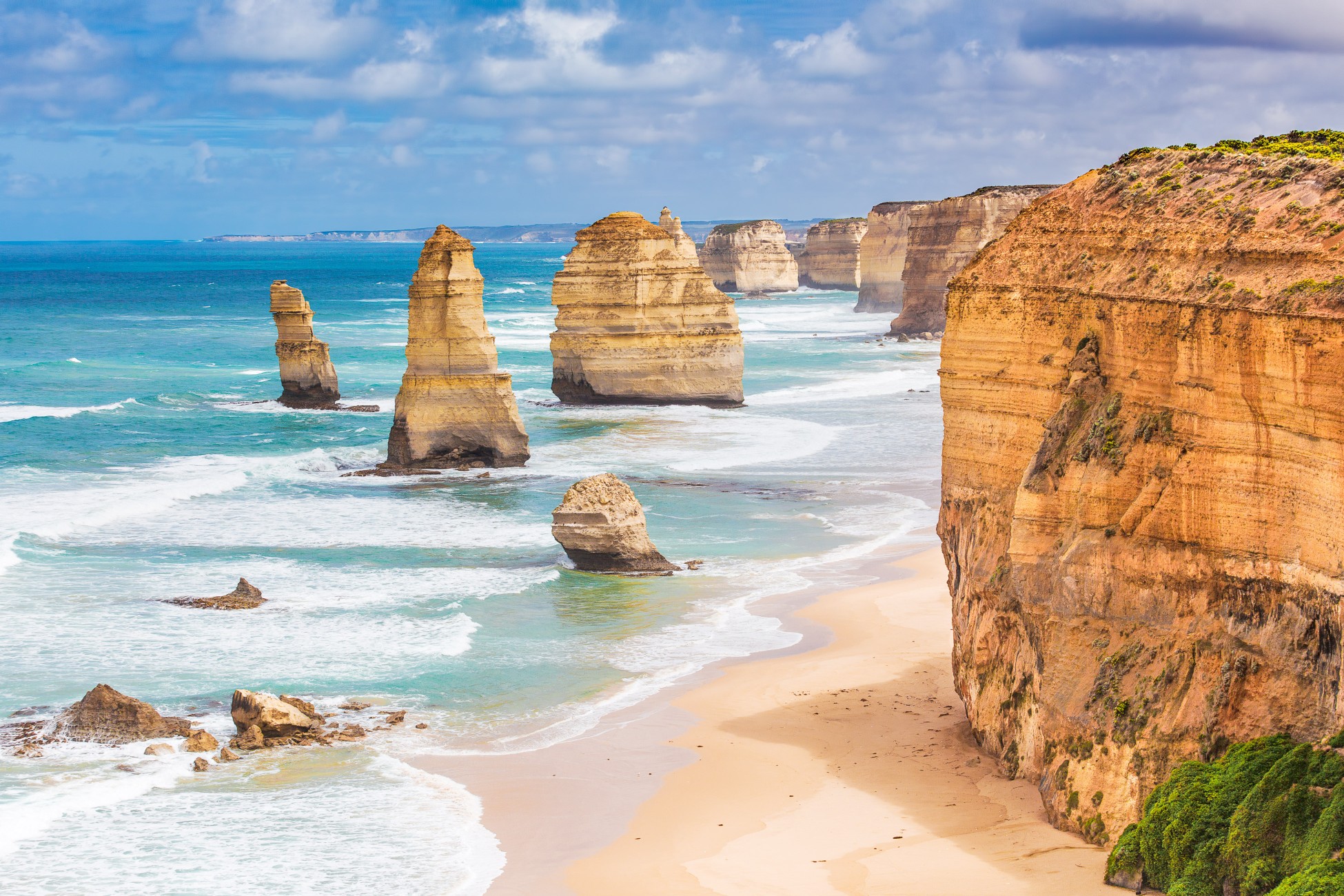 Twelve Apostles rock formations on the Great Ocean Road in Victoria, Australia with cliffs and turquoise ocean waves.