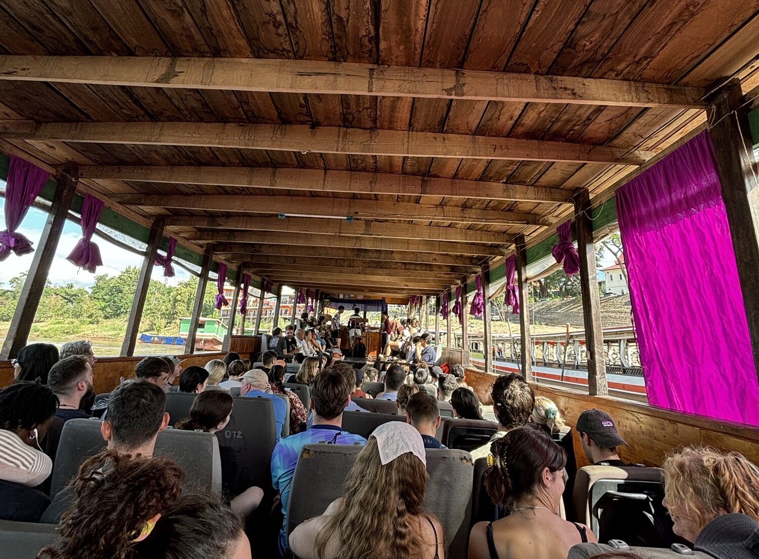 A slow boat from Thailand to Laos packed with travelers.