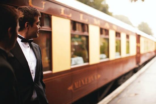 British Pullman train staff in tuxedos standing on the platform at London Victoria Station